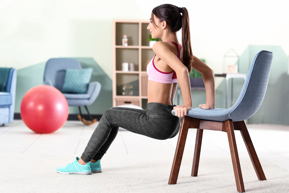Beautiful,Young,Woman,Doing,Exercises,With,Chair,At,Home